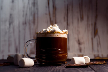 Delicious hot cocoa with marshmallows in a beautiful glass sprinkled with cocoa