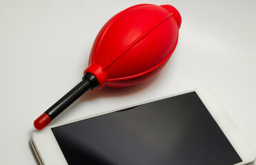 a tablet and a red vacuum cleaner or blower isolated on a white background