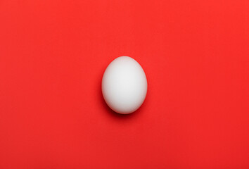 White egg on bright red background. Close-up macro flatlay, with texture. Food and Easter concept. - Powered by Adobe