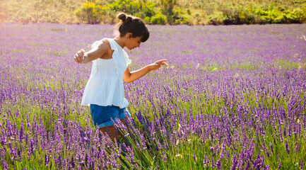 Happy girl enjoying nature in a lavender field in summer