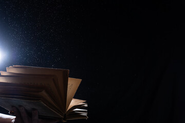 Open book on black isolated background with copy space. Concept of knowledge, wisdom and learning 