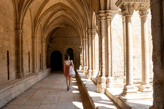 Tourist woman visiting the cloister of the cathedral of Arles, France,