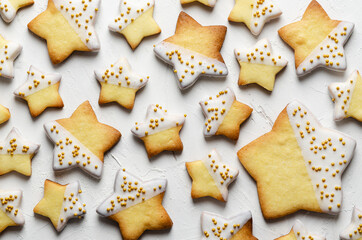 Star iced cookies with golden pearls, on a white backdrop. 