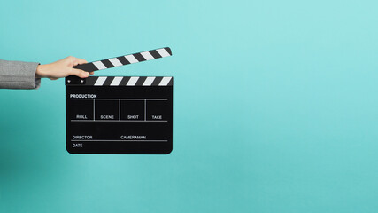 Black Clapperboard or movie Clapper board for videography with hands in grey suit. it use in video...