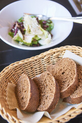 Kidney beans health salad. Dark table and white plate. Cafe menu. Green leaves and cheese fitness dinner. Organic vegetable diet. Black bread bowl. Vegan product. Fast eat.
