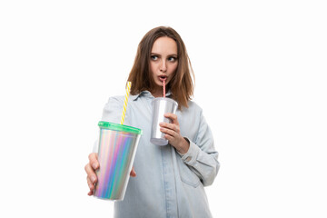 A young woman in a holds two shiny cocktail glasses on a white background