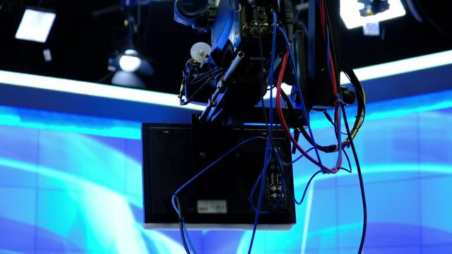 A camera with a prompter on it is moving over the crane arm. (Camera jib)