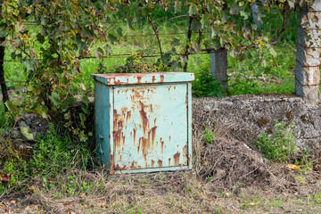 old color rusty metal box for electricity outside on the background of the fence