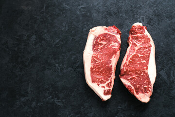 Raw New York striploin beef steak isolated on black background