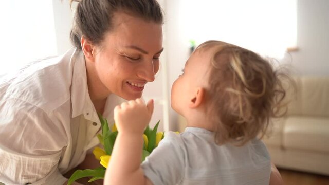 Close portrait of a little cute son kissing his mom congratulating her on March 8 or mothers day