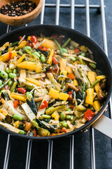 Fresh asian vegetables mix, Thai wok in a black pan on the black background with copy space. Healthy food