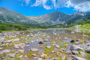 Musala peak mirroring at a surface of a mountain lake in bulgaria
