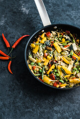 Fresh asian vegetables mix, Thai wok in a black pan on the black background with copy space. Healthy food