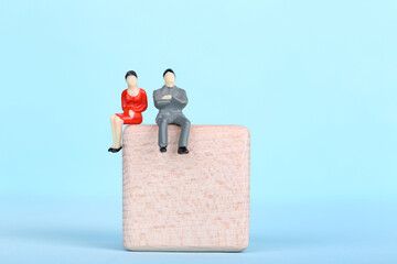 Miniature people with wooden cube on blue background - Powered by Adobe