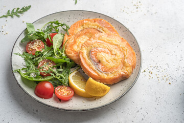 Salmon Pinwheel stuffed with cheese with salad and lemon