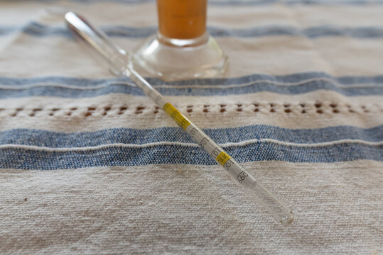 Measurement of alcohol content in beer. One of the most essential equipments in home brewing, hydrometer in a glass of beer. - Powered by Adobe