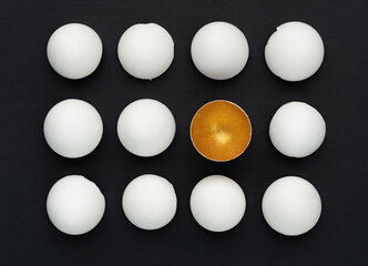 White and gold eggshell on a black background. The concept of difference among equals. Talent awakening concept. HR specialists search concept. The concept of being chosen.