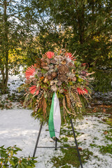 großer Herbstlich geschmückter Kranz mit Schleife auf einem Ständer