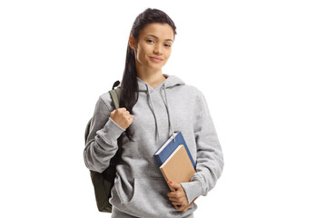 Schoolgirl with backpack and books smiling at the camera