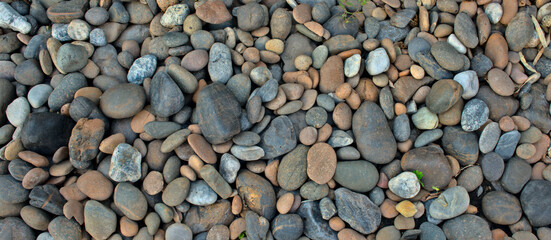 Natural colored pebble stones. Rock abstract texture background. Top view, horizontal image style.