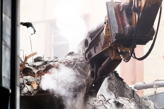 bridge destruction by demolition excavator in city street due to environmental problems and noise