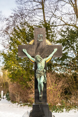 schöne Steinkreuz mit Jesus und einem goldenen Kranz