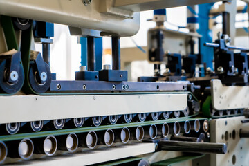 A industrial commercial envelope making machine, making paper envelopes for international distribution. Automated engineering machinery for mass production of paper envelopes.