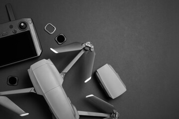 Modern drone with camera and video production equipment on black background, flat lay. Space for text