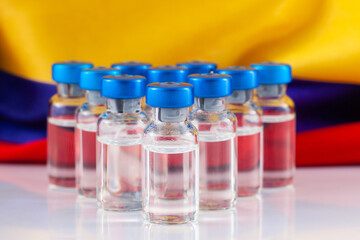 Vaccine vials and Colombian flag. Vaccination concept.