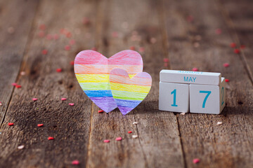 Wooden calendar with date 17 May and heart painted in rainbow color. International Day Against...