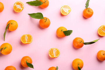 Fresh ripe tangerines with green leaves on pink background, flat lay