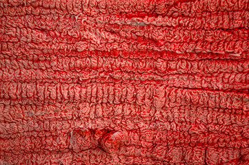 Texture of red oriental woolen carpet. Carpet texture. Rug surface close up