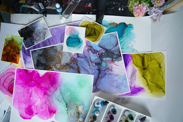 Table clutter in a creative studio. Alcohol Ink Painting. Above shot