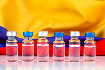 Vaccine vials and Colombian flag. Vaccination concept.