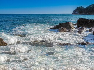waves hitting rocks in the summer sun in Budva, Montenegro