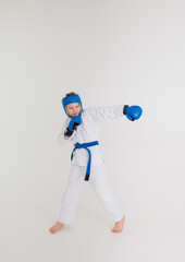 a boy in a white kimono with a blue belt makes a punch on a white background with space for text