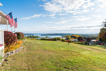 Deserted sloping lawn in a park overlooking a magnificent lake on a sunny autumn morning. Lake Winnipesaukee, NH, USA.