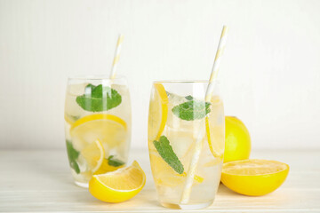 Cool freshly made lemonade and fruits on white wooden table