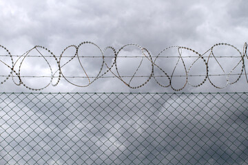 Barbed wire on the background of dramatic sky.