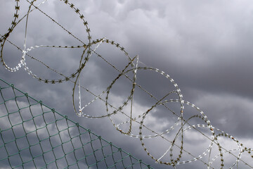 Barbed wire on the background of dramatic sky.