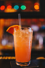 A fruity cocktail sits on a bar 