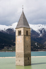 Close up of the iconic sunken bell tower of Curon surrounded by the water of Resia lake