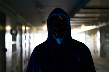 Masked criminal on the dark. Selective focus