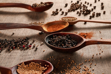 spoons of wood with different spices close up on a wooden table. selective focus