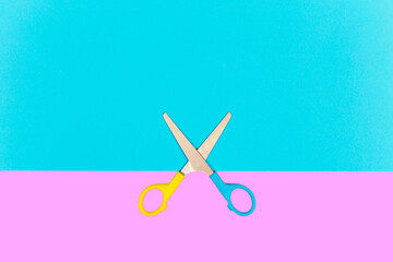 Colorful scissors on pastel pink and blue background