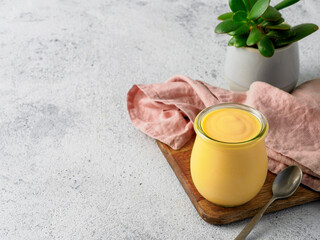 Yellow mango lassi on gray background. Indian mango yogurt drink with copy space left.