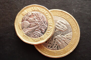 Macro closeup of one pound and two pound coins on top of each other.