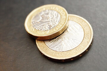 Macro closeup of one pound and two pound coins on top of each other.