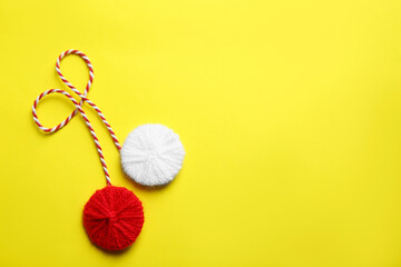 Traditional martisor on yellow background, top view with space for text. Beginning of spring celebration