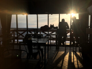 Couple relaxing inside of a restaurant after skiing near panoramic window with beautiful mountain view. Ski resort cafe on top of mountain.